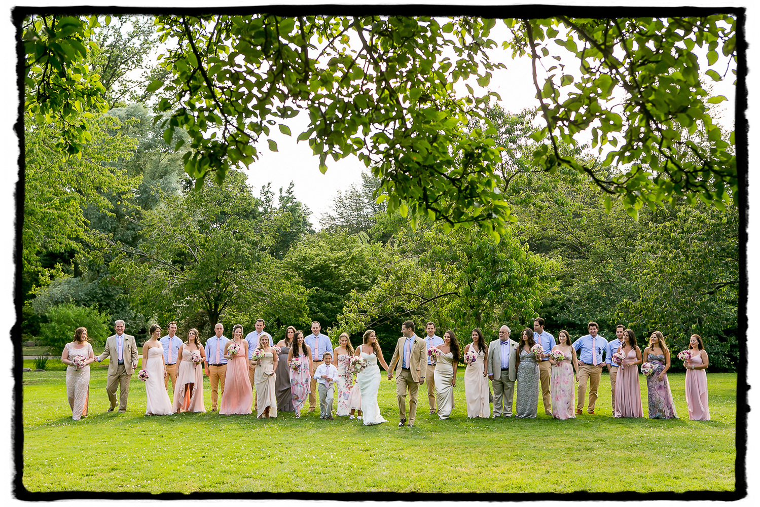 Rorie & Adam's wedding party in summer hues  take a stroll at The Brooklyn Botanic Garden.