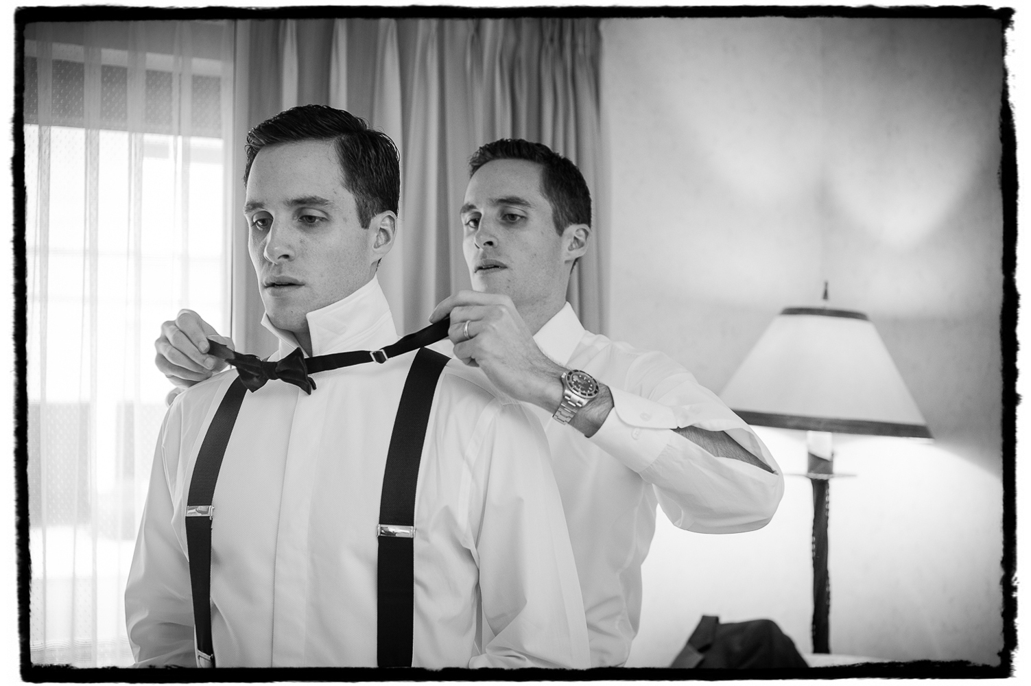 Mike's twin brother and best man helps him with the finishing touches on his tuxedo.