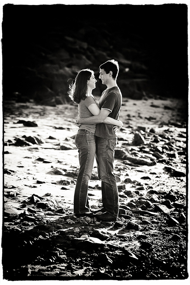 Engagement Portrait:  Julie & Andy share an embrace on the shore under the Manhattan Bridge in Brooklyn.